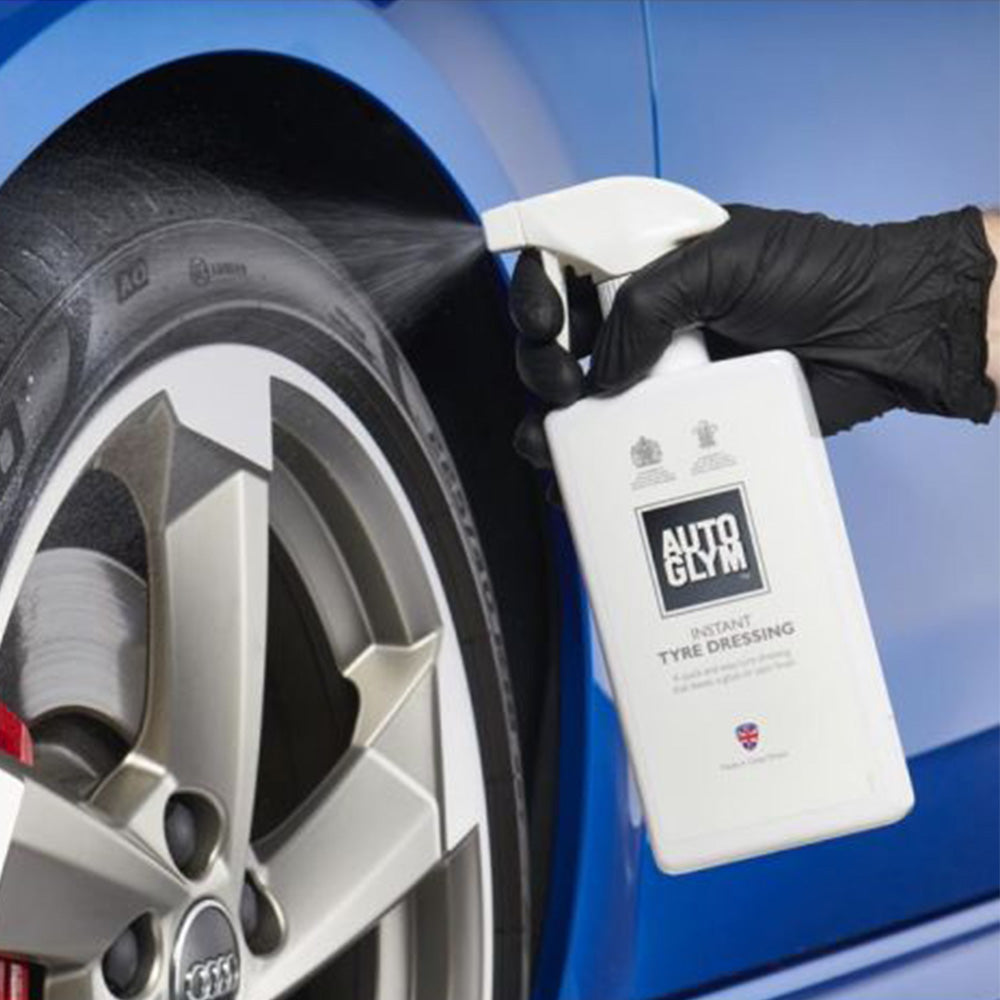 spraying Autoglym Instant Tyre Dressing on car wheel