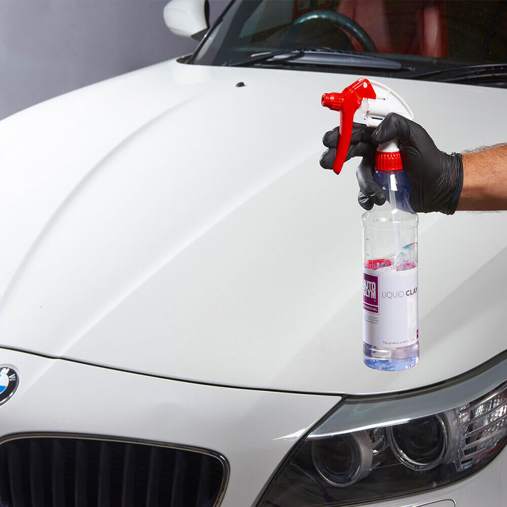 autoglym liquid clay in spray bottle held in front of car
