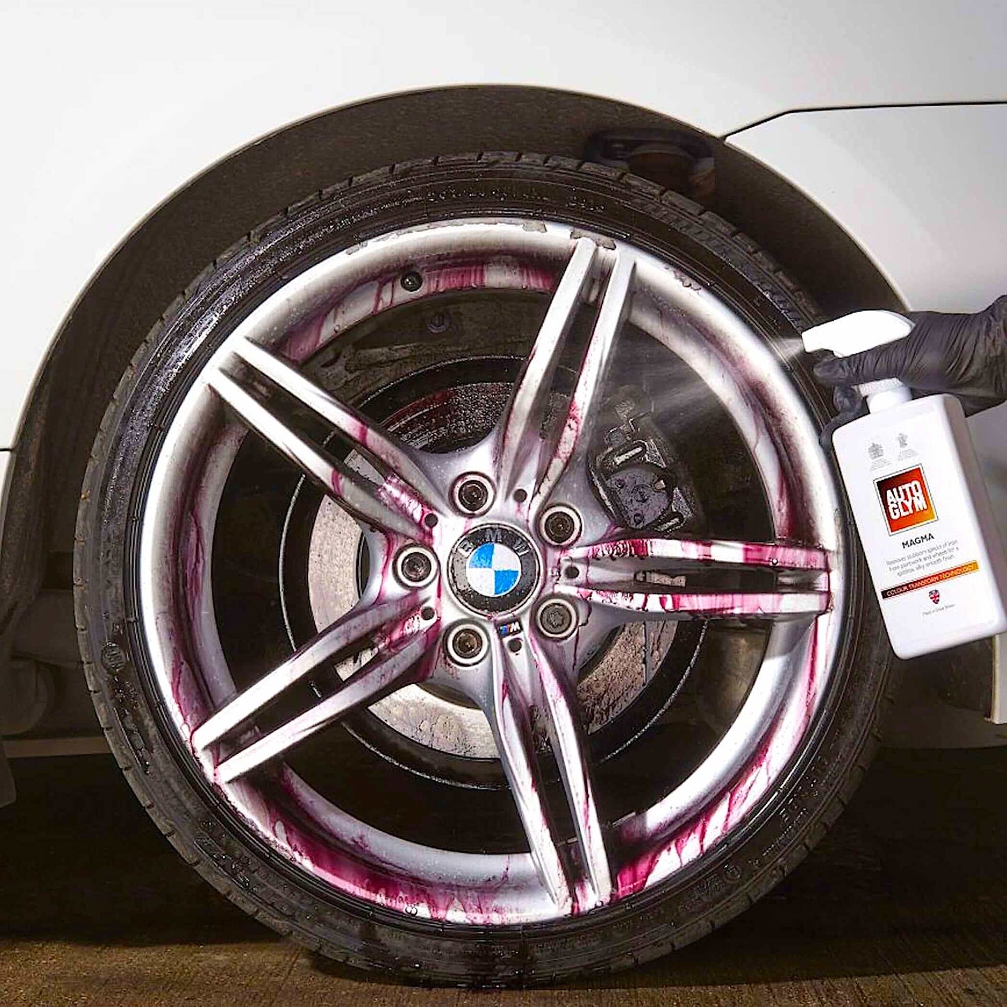 spraying autogly magma onto car wheel