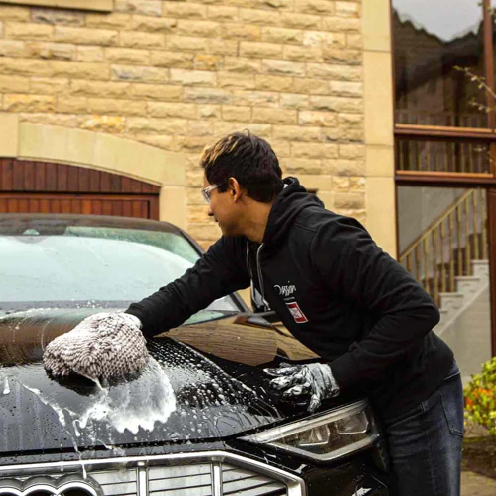 man washing car with autoglym shampoo
