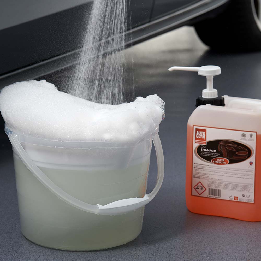 filling bucket with water and car shampoo