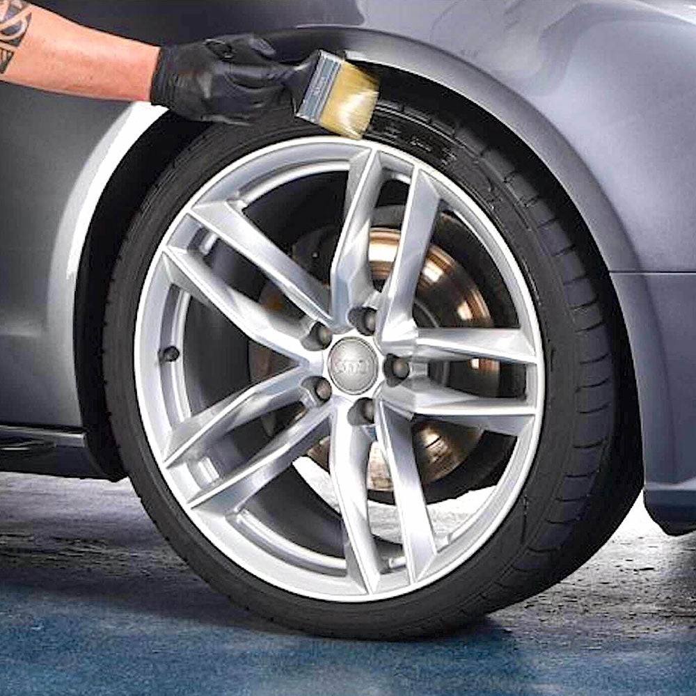 applying autoglym rubber plus cleaner with brush to car tyre